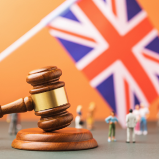 Wooden judge gavel flag and plastic toys the concept of trials in the British Society