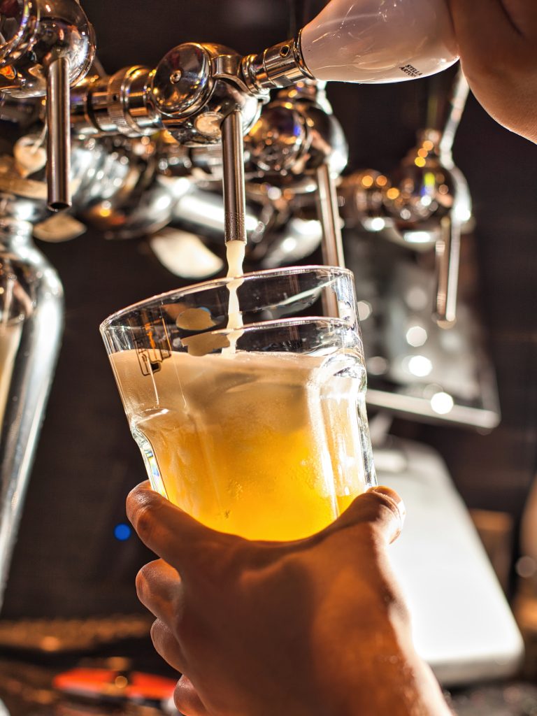 Pouring Beer Into Glass At Bar